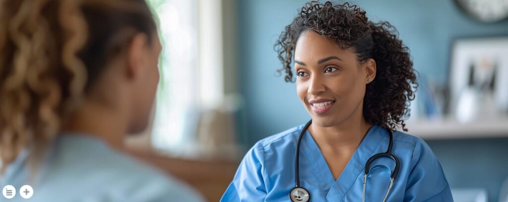 Healthcare professional smiling while talking to a patient in a medical setting.